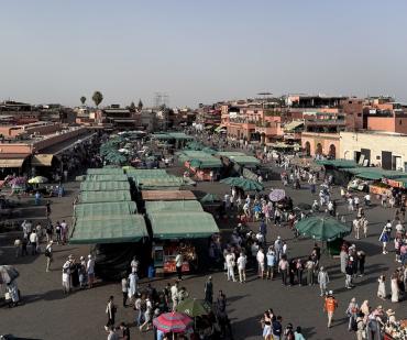 Vue animée de la place Jemaa el-Fna à Marrakech en journée – étape du circuit de 8 jours au Maroc depuis Casablanca